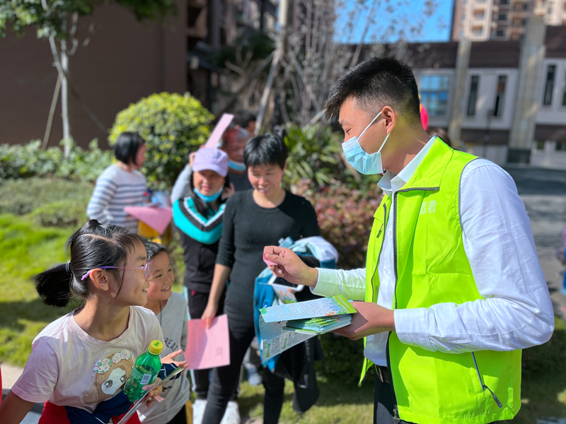 /QJ_834241658240.jpg 志愿者向居民介绍垃圾分类的方法.JPG